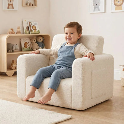 Fauteuil enfant blanc cassé, enfant assis sur l’assise rembourrée avec accoudoirs