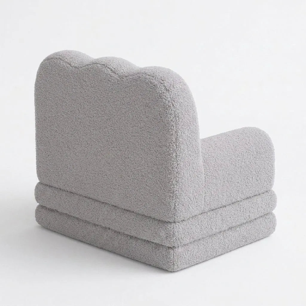 Fauteuil enfant gris moelleux, vue de côté, assise rembourrée et dossier arrondi texturé