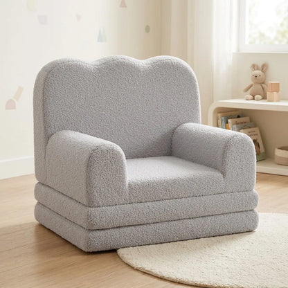 Fauteuil enfant rembourré gris, forme compacte, accoudoirs larges et assise confortable