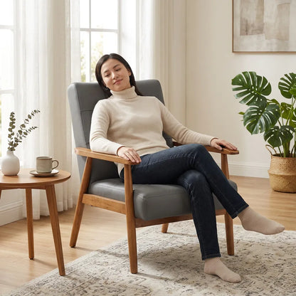 Fauteuil de salon en cuir gris, accoudoirs, assise rembourrée, structure en noyer.