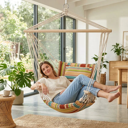 Fauteuil suspendu hamac rayé multicolore, cordes tressées blanches et barre en bois.