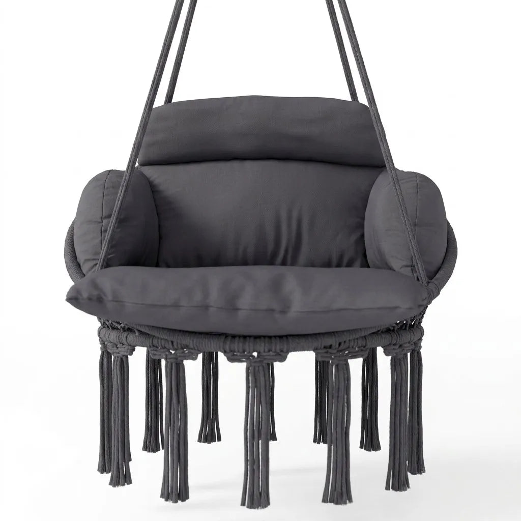 Fauteuil suspendu en macramé sombre, coussin épais, accoudoirs arrondis, franges