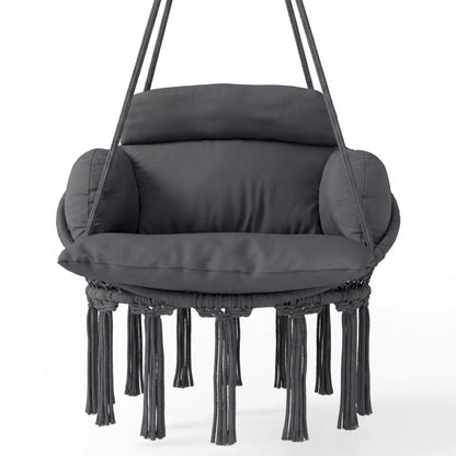 Fauteuil suspendu en macramé sombre, coussin épais, accoudoirs arrondis, franges