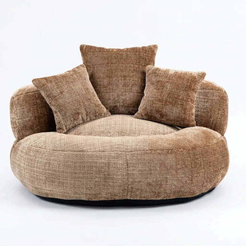 Fauteuil rond en tissu beige avec dossier haut et trois coussins.