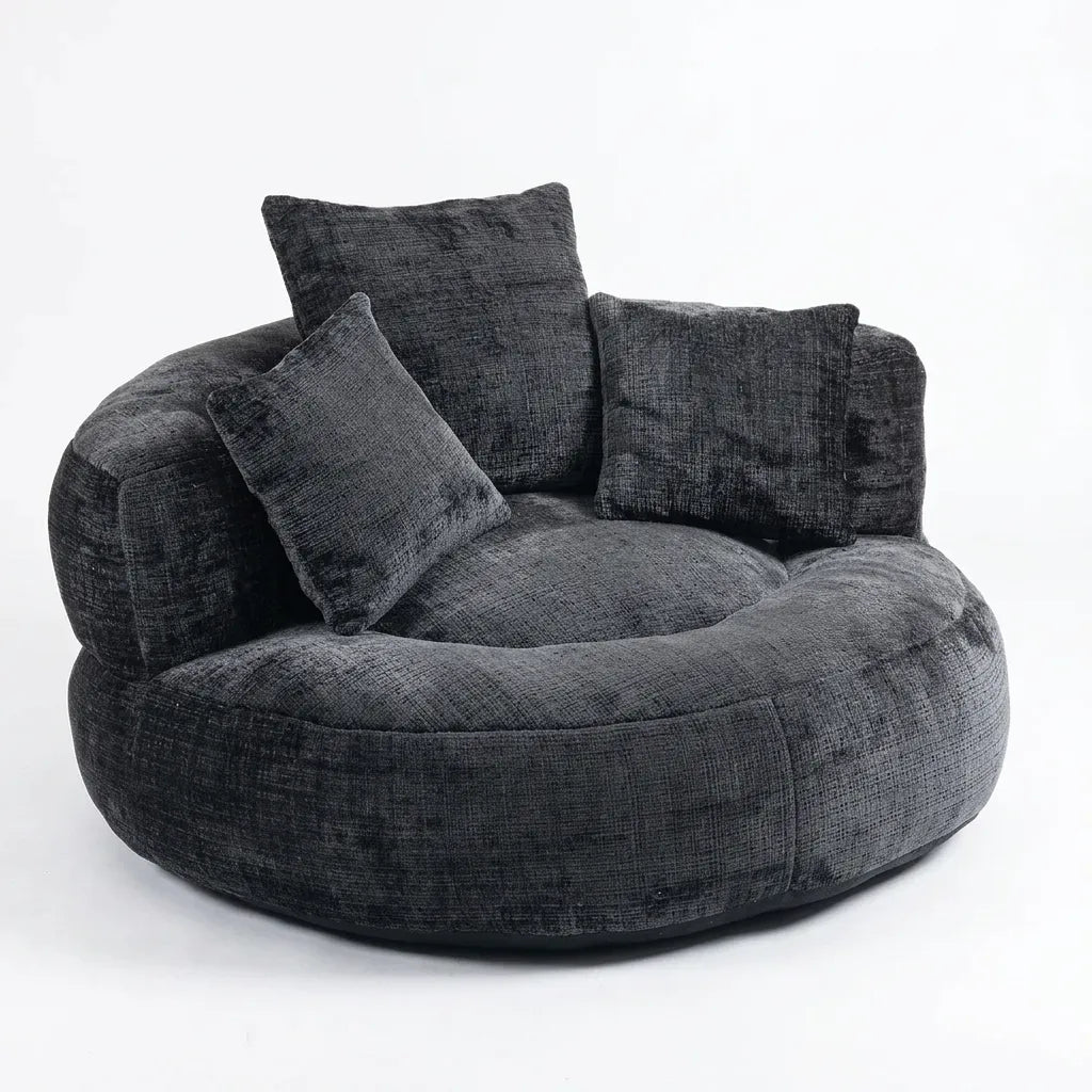 Fauteuil rond en tissu gris foncé avec dossier haut et quatre coussins.