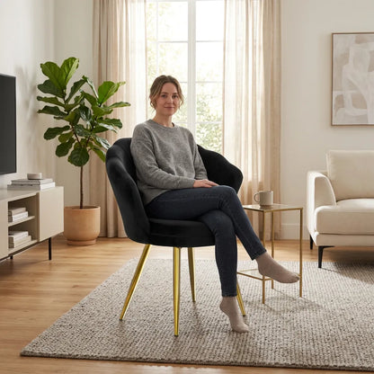 Fauteuil gris foncé avec accoudoirs arrondis et pieds métalliques dorés.