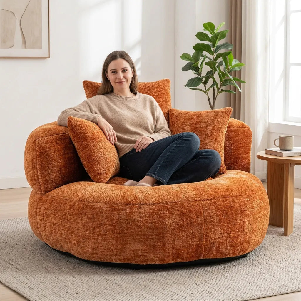 Fauteuil rond en tissu orange avec dossier haut et trois coussins.